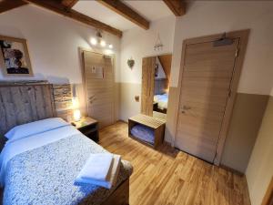 una camera con letto e porta con specchio di Hotel Tarvisio a Tarvisio