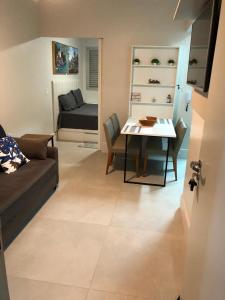 een woonkamer met een bank en een tafel bij Canto do Forte - AP 106CD in Praia Grande