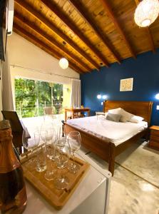 1 dormitorio con 1 cama y copas de vino en una mesa en Flor de Lis Chalés en Parati