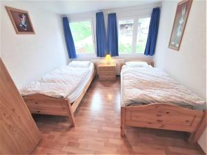2 camas en una habitación con 2 ventanas en First : ski-out for 4 in the central Chalet Diana, en Bettmeralp