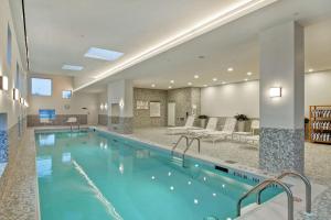 a swimming pool in a hotel room with a hotel at Home2 Suites By Hilton Montreal Dorval in Dorval