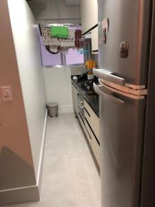 een keuken met een roestvrijstalen koelkast in een kamer bij Canto do Forte - AP 106CD in Praia Grande