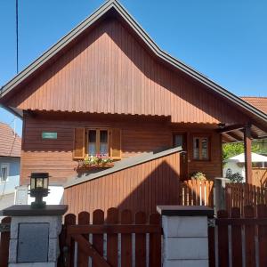 a small house with a wooden fence and a gate at Kellerstöckl Maierjörgl in Sankt Martin im Sulmtal +2 photos