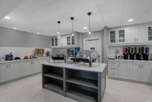 uma grande cozinha com armários brancos e um balcão em Homewood Suites by Hilton London Ontario em London