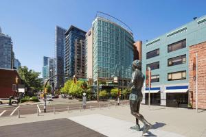 Una statua di un uomo che cammina in una strada di città di Hampton Inn & Suites, by Hilton - Vancouver Downtown a Vancouver