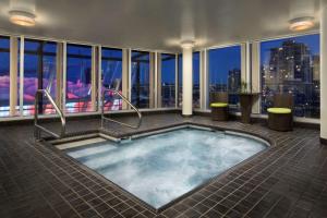 a hot tub in a room with a view of the city at Hampton Inn & Suites, by Hilton - Vancouver Downtown in Vancouver