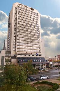 a large building with cars parked in a parking lot at Doubletree by Hilton London in London