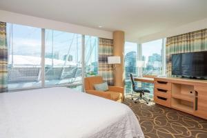 Habitación de hotel con cama, escritorio y TV. en Hampton Inn & Suites, by Hilton - Vancouver Downtown en Vancouver