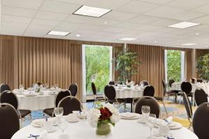 una sala de conferencias con mesas y sillas con flores. en Hampton Inn & Suites, by Hilton - Vancouver Downtown, en Vancouver