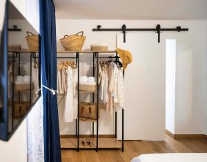 a room with a closet with clothes on racks at Diomira Apartment in Taormina