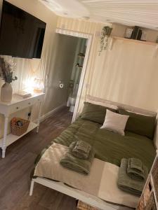 a bedroom with a bed with two towels on it at The Cotswold Nook in Dursley