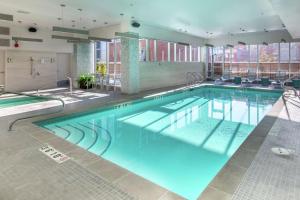 - une grande piscine d'eau bleue dans un bâtiment dans l'établissement Hilton Garden Inn Calgary Downtown, à Calgary