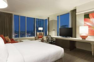 Habitación de hotel con cama y escritorio con TV. en Hilton Garden Inn Calgary Downtown, en Calgary