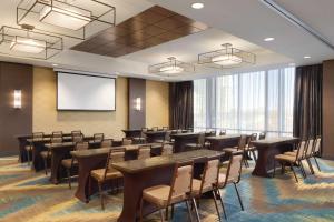a conference room with tables and chairs and a screen at Hilton Garden Inn Calgary Downtown in Calgary