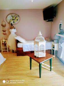 una camera con un letto e una gabbia per uccelli su un tavolo di Chambre "Rose" 