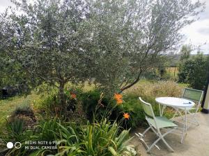 a table and two chairs in a garden at Chambre "Rose" in Pajay