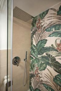 e bagno con doccia e carta da parati tropicale. di Diomira Apartment a Taormina