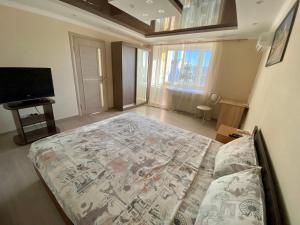 a bedroom with a large bed and a television at Apartment on Khreshchatyk 200 center in Cherkasy