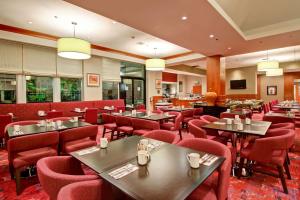 a restaurant with tables and red chairs at Hilton Garden Inn Toronto/Markham in Thornhill