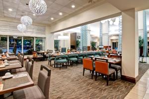 une salle à manger avec des tables et des chaises dans un restaurant dans l'établissement Hilton Garden Inn Toronto/Burlington, à Burlington