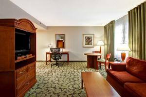 Habitación de hotel con sofá, TV y escritorio. en Hilton Garden Inn Toronto/Markham, en Thornhill