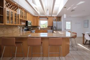 a kitchen with a large island with bar stools at Bean Point Residence in Anna Maria