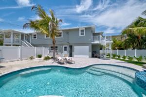 a house with a swimming pool in front of a house at Bean Point Residence in Anna Maria