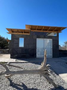 a tree branch on the ground in front of a house at Glamping Risco Xodhe Cactus in Tecozautla