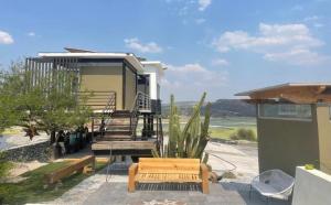 a house with stairs and a bench on a patio at Glamping Risco Xodhe Cactus in Tecozautla