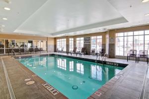 una piscina en un hotel con sillas y mesas en Homewood Suites by Hilton Toronto-Markham en Markham