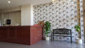 a lobby with a counter and a chair and a wall at T-Bird Grand Hotel Trang ทีเบิร์ดแกรนด์ in Trang