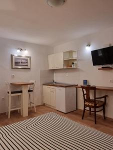 a kitchen with a desk and a table and a table and chairs at Studio Riva in Hvar +15 photos