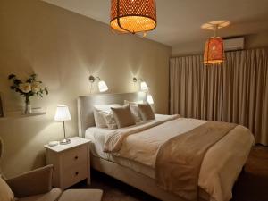een slaapkamer met een bed, een stoel en verlichting bij Luxury appt for 6: mesmerizing Spanish water view in Jan Thiel