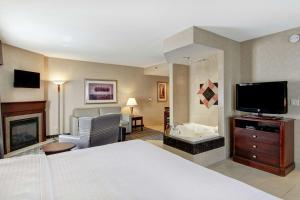 a hotel room with a bed and a television at Homewood Suites by Hilton Toronto-Oakville in Oakville