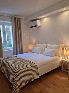 Un dormitorio con una cama con una manta a rayas. en Studio Riva, en Hvar