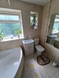 a bathroom with a tub and a toilet and a sink at Colne House in Yiewsley
