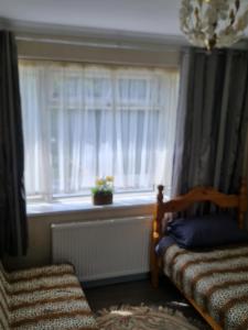 a bedroom with a window and a bed and a chair at Colne House in Yiewsley