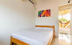 a bed in a room with a painting on the wall at red moon in Santa Marta
