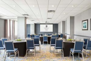 a conference room with tables and chairs and a screen at Embassy Suites By Hilton Toronto Airport in Toronto