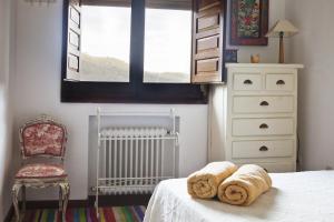 a bedroom with a bed with a radiator and a chair at El Rincón del Tiétar in Santa Maria del Tietar +43 photos