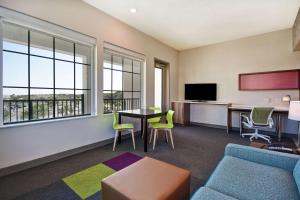 a living room with a couch and a table and chairs at Home2 Suites By Hilton Jekyll Island in Jekyll Island