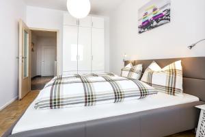 1 dormitorio blanco con 1 cama grande con almohadas a rayas en Andreas Hofer Residence, en Bolzano