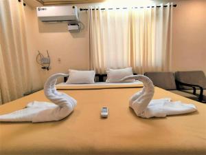 two towel swans on a table in a hospital room at Shradha luxury room in Calangute