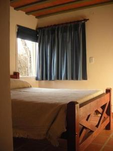 a bedroom with a large bed with a window at Cabañas Mayma in Vaqueros