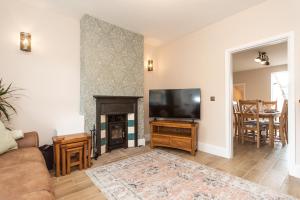 a living room with a fireplace and a flat screen tv at The Bell Chime, renovated 3 bedroom cottage in Matlock in Matlock Bank
