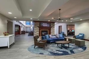 a living room with a blue couch and a fireplace at Homewood Suites by Hilton Fort Collins in Fort Collins