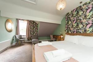 a bedroom with a bed with a floral accent wall at The Bell Chime, renovated 3 bedroom cottage in Matlock in Matlock Bank