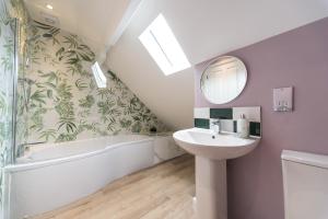 ein Badezimmer mit Waschbecken, Badewanne und Spiegel in der Unterkunft The Bell Chime, renovated 3 bedroom cottage in Matlock in Matlock Bank + 8 Fotos