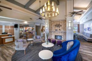 a living room with a blue couch and chairs and a fireplace at Homewood Suites Memphis Germantown in Memphis