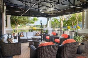 une terrasse couverte avec des chaises et des canapés en osier dans l'établissement The Terrace Hotel Lakeland, Tapestry Collection by Hilton, à Lakeland